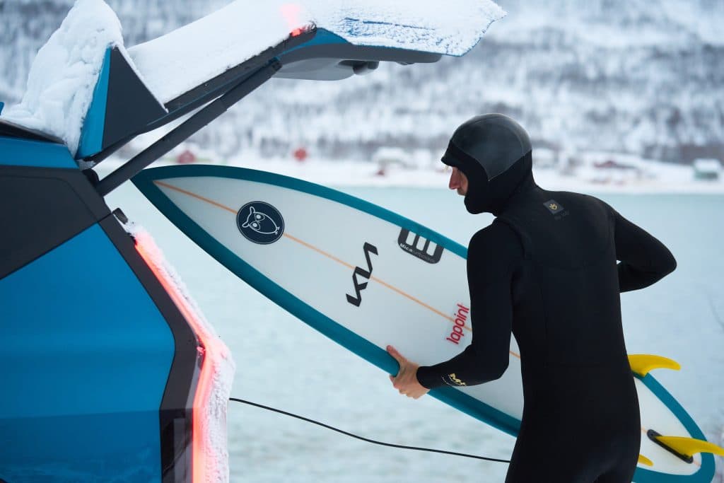 Tim Latte stoppar surfingbrädan i bakluckan på sin bil.