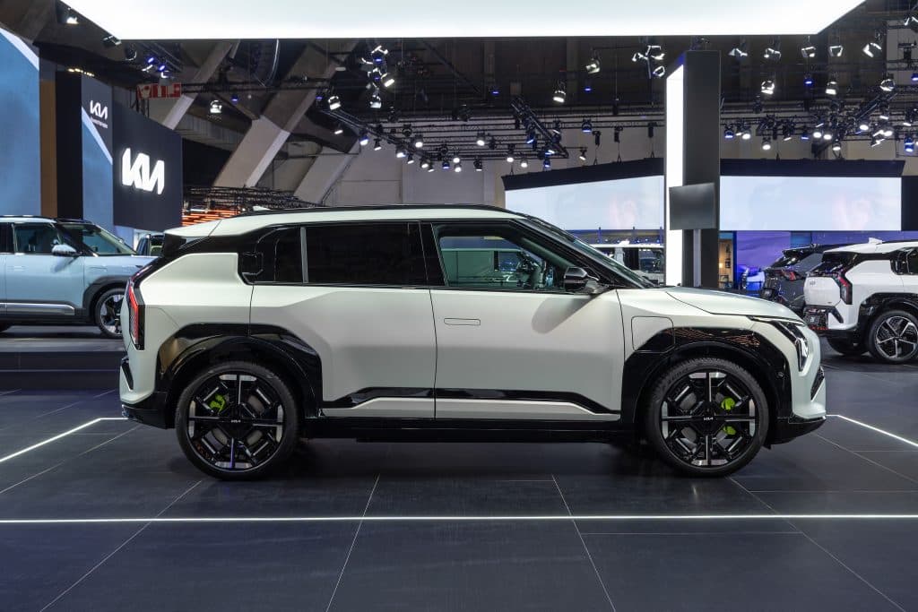 Kia EV3 GT syns från sidan i mässmiljö.